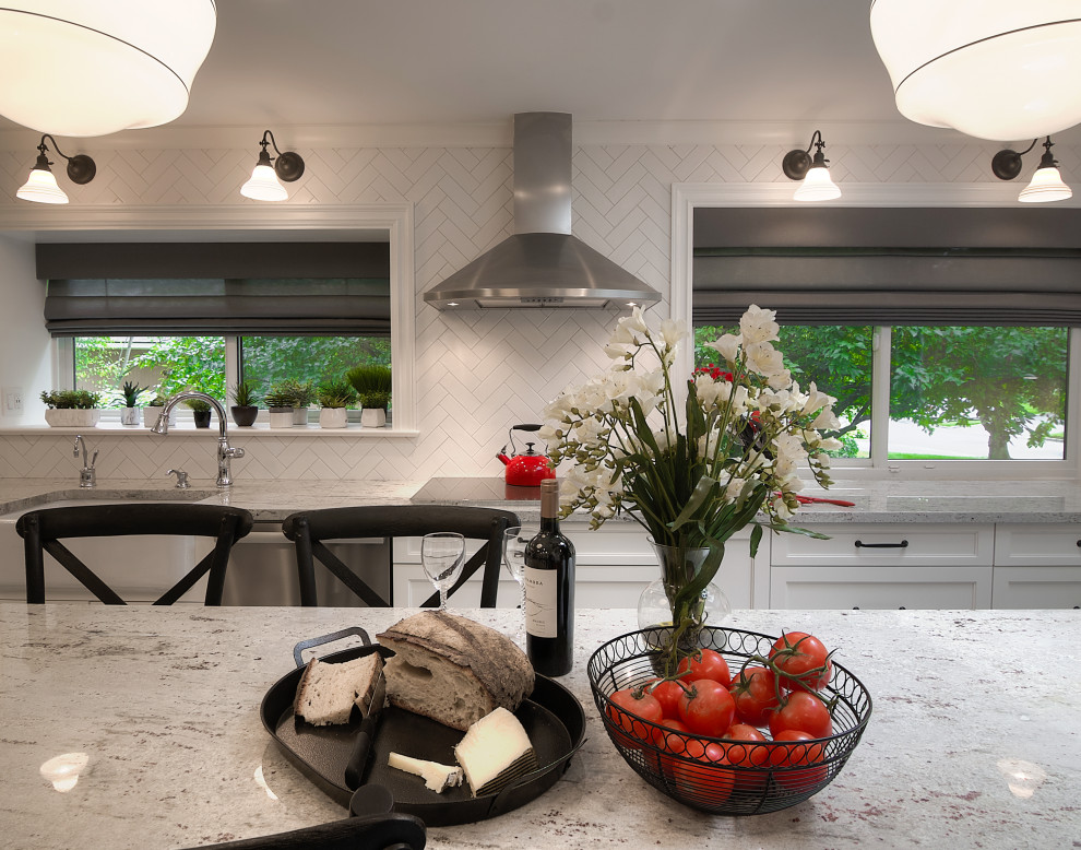 Inspiration for a transitional u-shaped multicolored floor enclosed kitchen remodel with a farmhouse sink, recessed-panel cabinets, white cabinets, granite countertops, white backsplash, subway tile backsplash, stainless steel appliances, an island and beige countertops