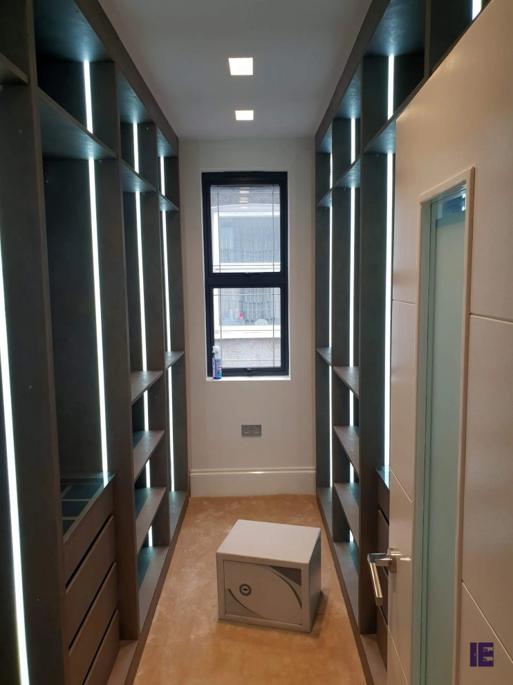 This is an example of a small contemporary built-in wardrobe in London with flat-panel cabinets and brown cabinets.