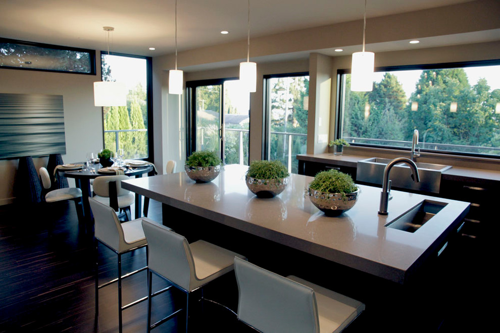 This is an example of a mid-sized modern l-shaped open plan kitchen in Vancouver with a farmhouse sink, flat-panel cabinets, dark wood cabinets, quartz benchtops and stainless steel appliances.