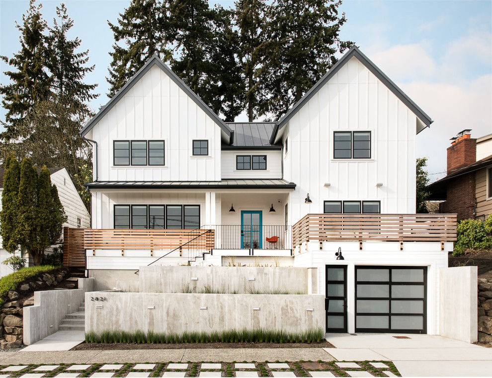 Country two-storey white house exterior in Seattle with a gable roof and a metal roof.