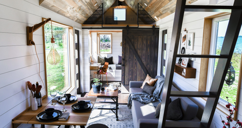 Small country loft-style living room in Other with white walls, cork floors, black floor, timber and planked wall panelling.