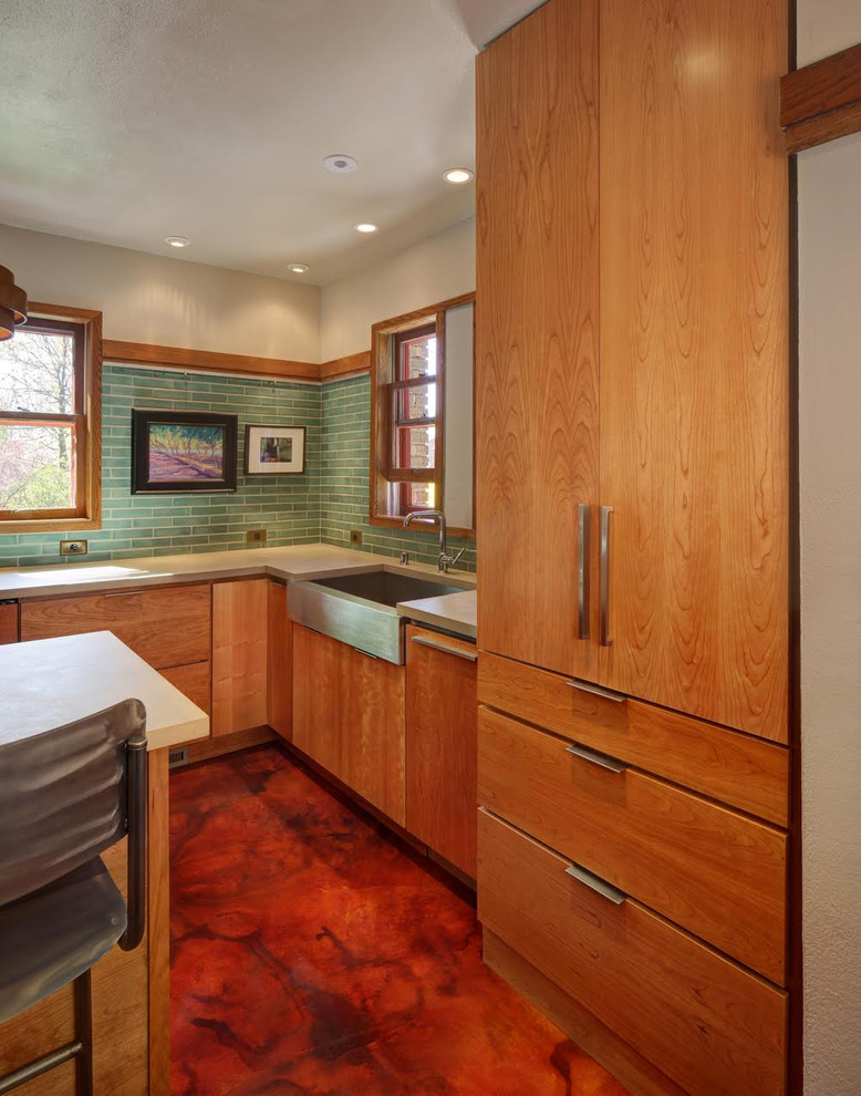 Mid-sized midcentury l-shaped eat-in kitchen in Milwaukee with a farmhouse sink, flat-panel cabinets, medium wood cabinets, green splashback, ceramic splashback, stainless steel appliances and with island.
