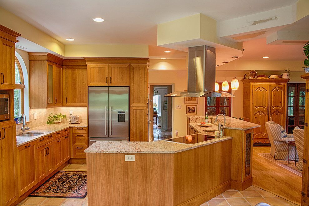Photo of a mid-sized traditional l-shaped open plan kitchen in DC Metro with an undermount sink, beaded inset cabinets, light wood cabinets, granite benchtops, beige splashback, stone slab splashback, stainless steel appliances, a peninsula, beige floor and terra-cotta floors.