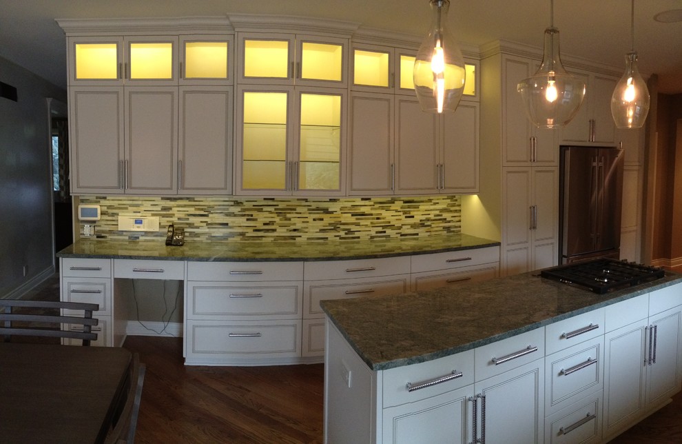Mid-sized transitional u-shaped medium tone wood floor and brown floor eat-in kitchen photo in Omaha with an undermount sink, raised-panel cabinets, white cabinets, granite countertops, multicolored backsplash, mosaic tile backsplash, stainless steel appliances, an island and gray countertops