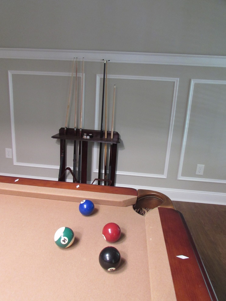 Large transitional walk-out vinyl floor basement photo with beige walls, a standard fireplace and a stone fireplace