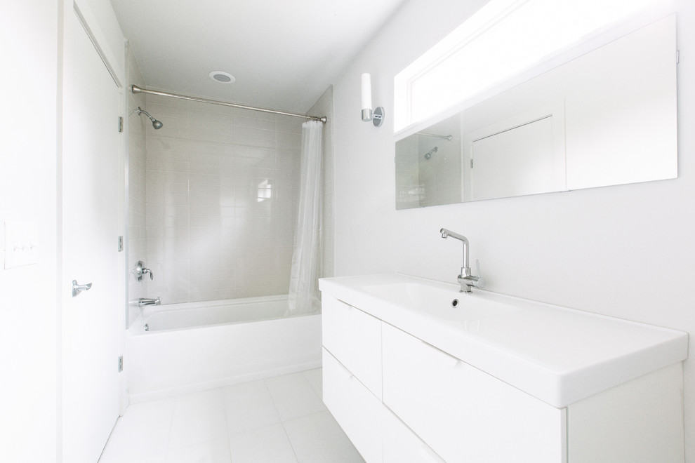 Photo of a small modern bathroom in Charlotte with white cabinets, white tile, ceramic tile, white walls and ceramic floors.