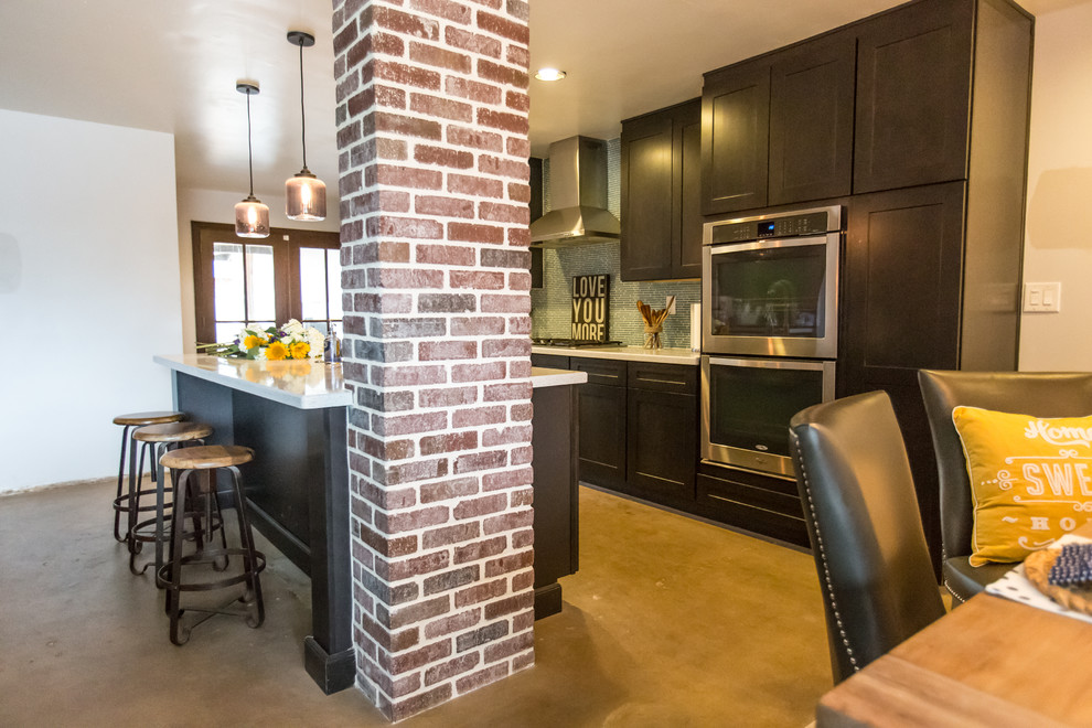 Inspiration for a mid-sized rustic single-wall concrete floor and gray floor open concept kitchen remodel in Phoenix with dark wood cabinets, blue backsplash, stainless steel appliances, an island, an undermount sink, shaker cabinets, quartzite countertops and glass tile backsplash