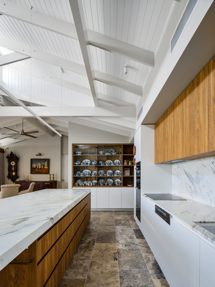This is an example of a mid-sized midcentury galley open plan kitchen in Gold Coast - Tweed with a double-bowl sink, recessed-panel cabinets, white cabinets, marble benchtops, white splashback, marble splashback, white appliances, travertine floors, with island, beige floor, white benchtop and exposed beam.