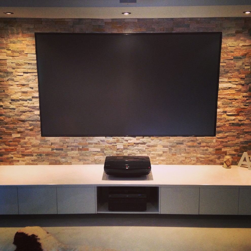 Inspiration for a large modern open concept home theatre in Sunshine Coast with multi-coloured walls, concrete floors and a built-in media wall.