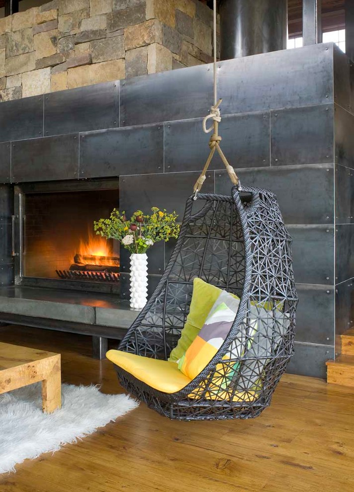 This is an example of a country living room in Denver with a metal fireplace surround.