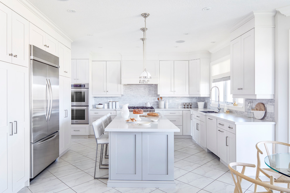 Inspiration for a traditional u-shaped eat-in kitchen in Toronto with an undermount sink, shaker cabinets, white cabinets, grey splashback, mosaic tile splashback, stainless steel appliances and with island.