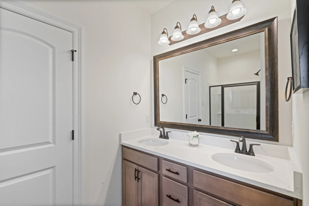 This is an example of a mid-sized traditional master bathroom in New Orleans with brown cabinets, an alcove tub, an alcove shower, white walls, vinyl floors, a wall-mount sink, brown floor, a hinged shower door, white benchtops, a double vanity and a built-in vanity.