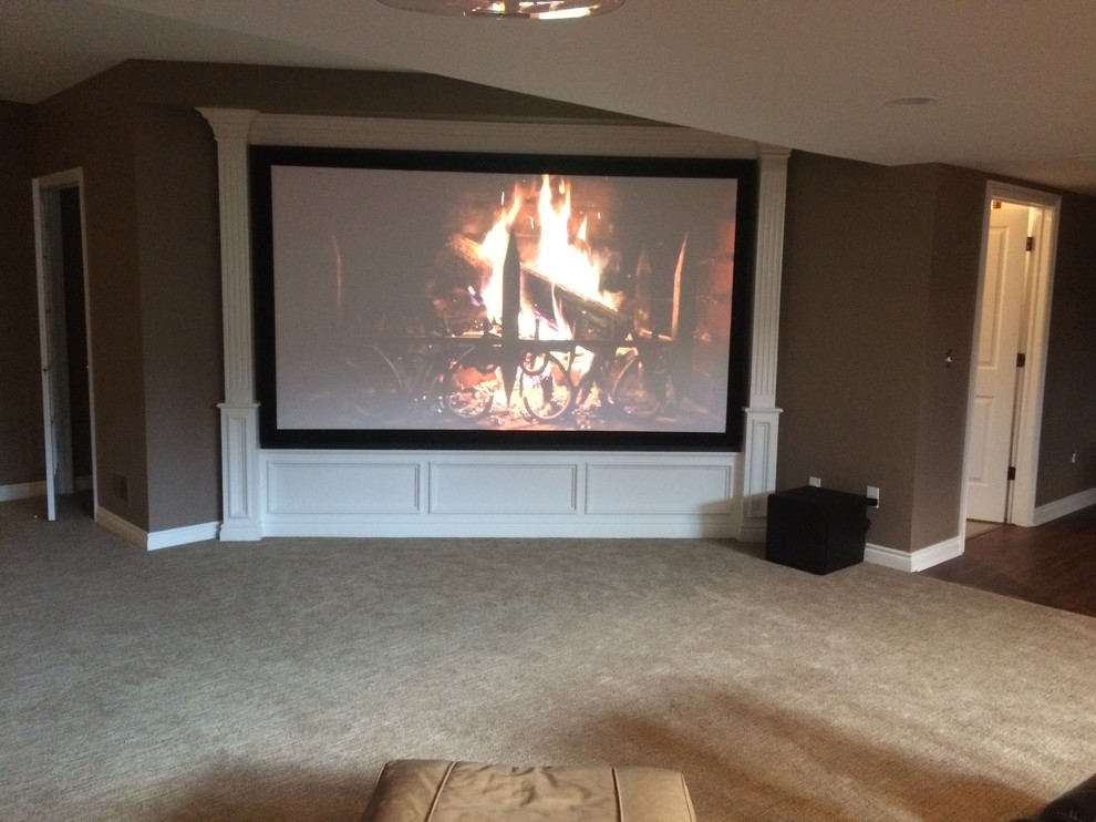 Inspiration for a mid-sized traditional open concept home theatre in Detroit with brown walls, carpet and a projector screen.