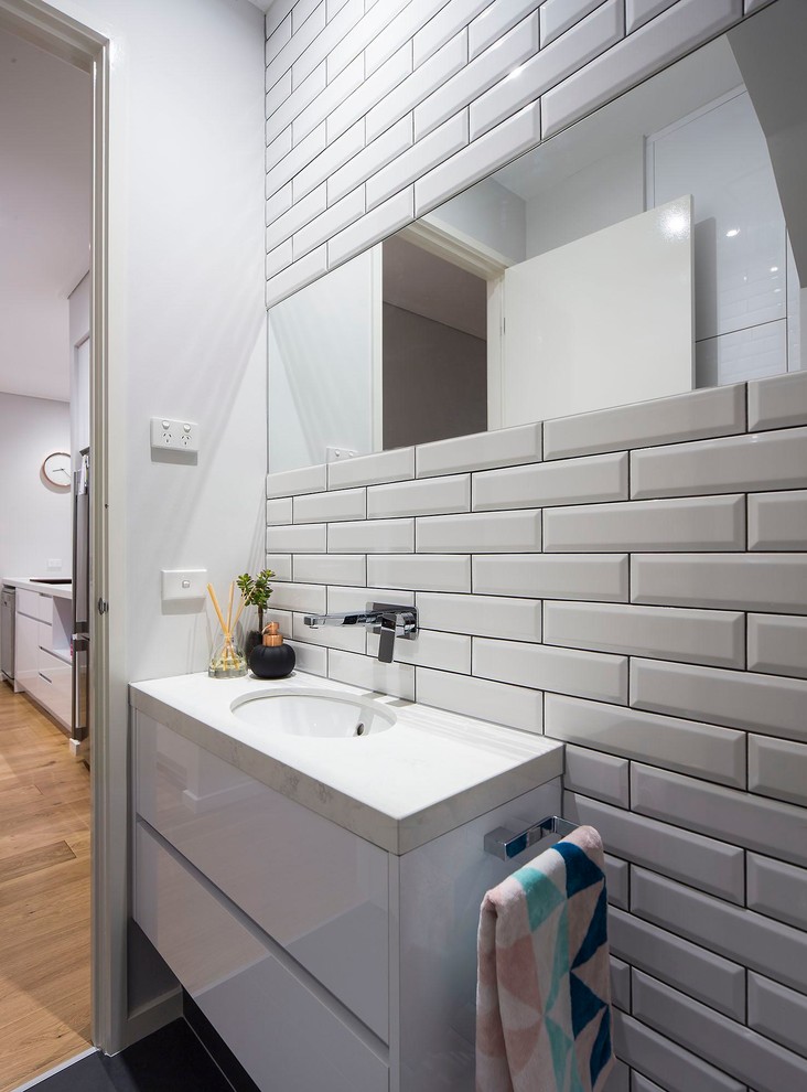 Design ideas for a contemporary bathroom in Melbourne with white cabinets, a one-piece toilet, white tile, subway tile, white walls, ceramic floors, an integrated sink and granite benchtops.