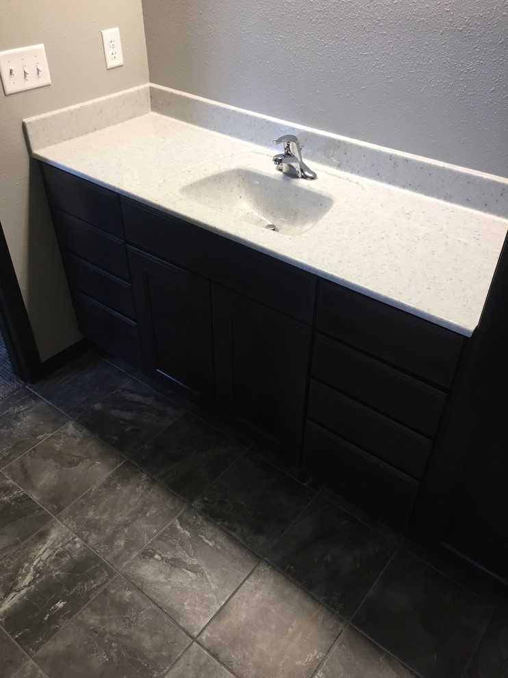 Inspiration for a mid-sized traditional master bathroom in Other with flat-panel cabinets, black cabinets, grey walls, ceramic floors, an integrated sink, onyx benchtops and grey floor.
