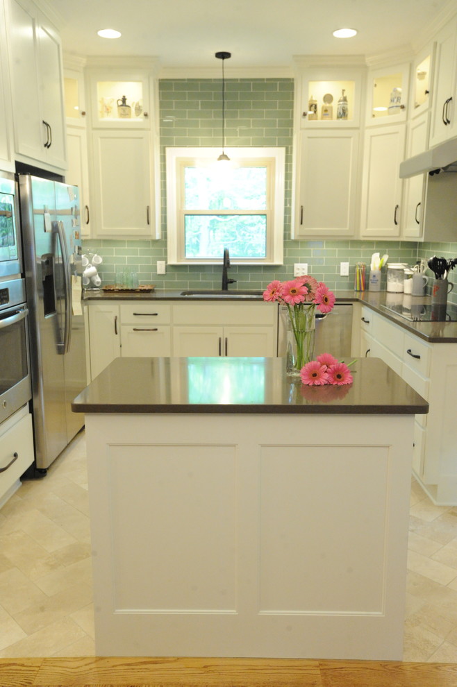 Example of a transitional u-shaped travertine floor kitchen design in Atlanta with a single-bowl sink, recessed-panel cabinets, white cabinets, quartz countertops, green backsplash, glass tile backsplash, stainless steel appliances and an island