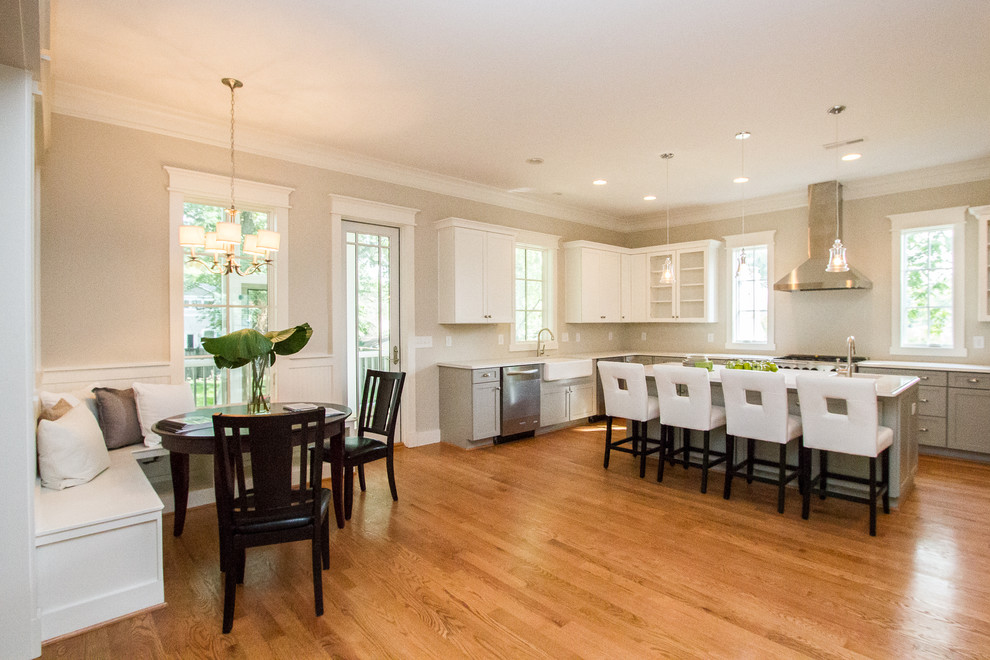 Large u-shaped eat-in kitchen with a farmhouse sink, recessed-panel cabinets, grey cabinets, quartz benchtops, stainless steel appliances, medium hardwood floors and with island.