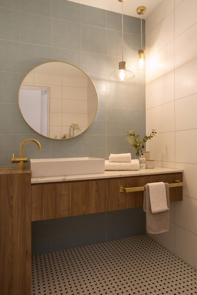 Design ideas for a small traditional powder room in Gold Coast - Tweed with recessed-panel cabinets, medium wood cabinets, a wall-mount toilet, blue tile, porcelain tile, blue walls, mosaic tile floors, a vessel sink, marble benchtops and white floor.