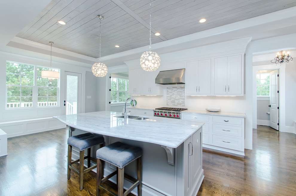 Design ideas for a large country u-shaped eat-in kitchen in Raleigh with an undermount sink, shaker cabinets, white cabinets, marble benchtops, white splashback, stainless steel appliances, dark hardwood floors and with island.