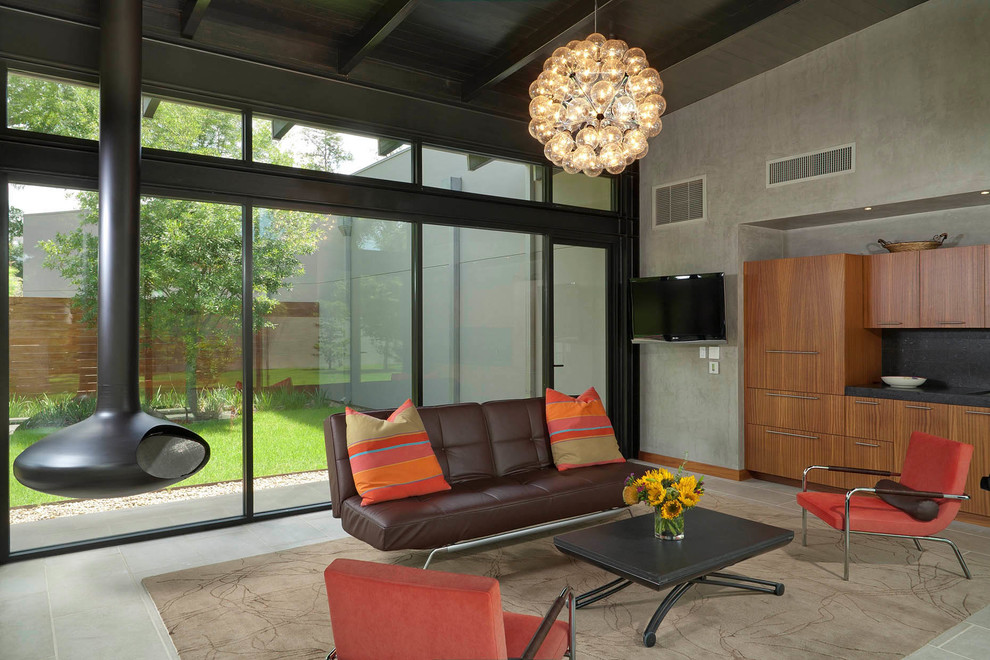 Photo of a modern family room in Houston with grey walls and a hanging fireplace.