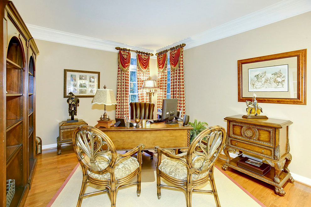 This is an example of a mid-sized eclectic study room in Baltimore with light hardwood floors, no fireplace, a freestanding desk and beige walls.
