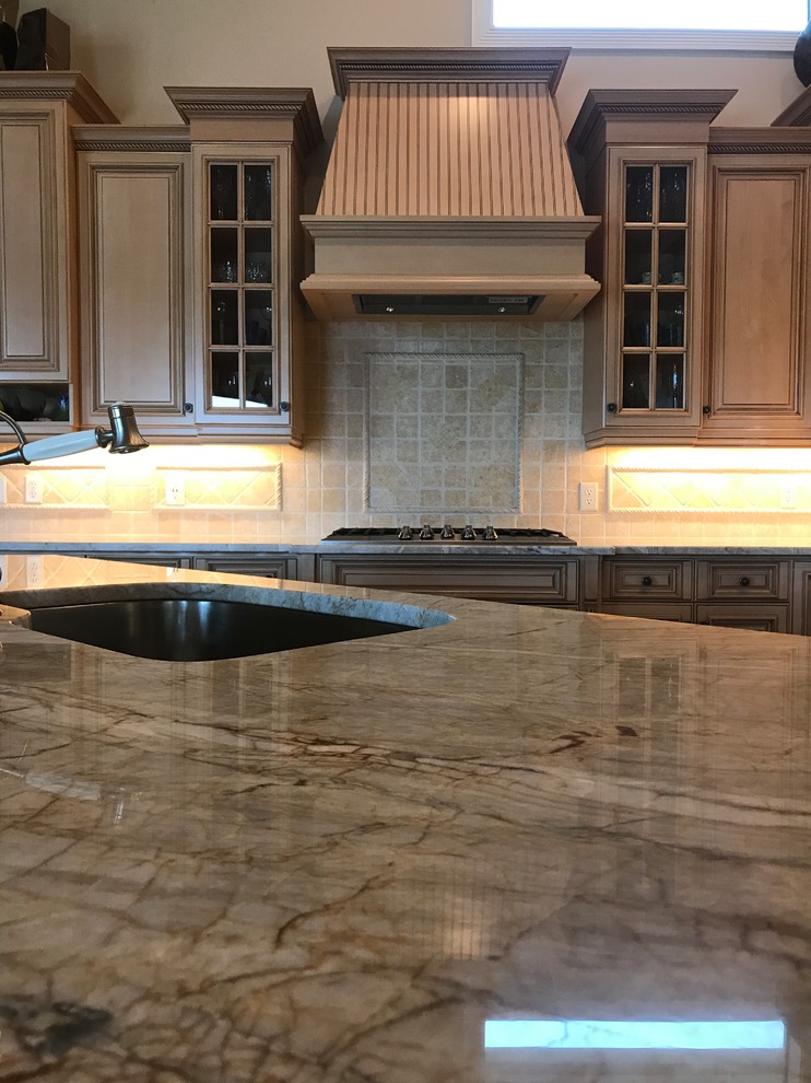 Example of a mid-sized transitional l-shaped brown floor kitchen design in Miami with an undermount sink, raised-panel cabinets, light wood cabinets, paneled appliances and an island