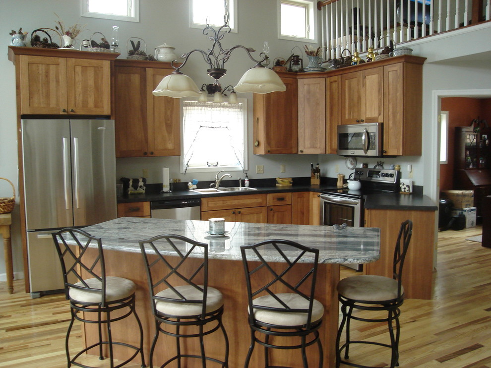 Inspiration for a large transitional l-shaped light wood floor kitchen remodel in DC Metro with a drop-in sink, shaker cabinets, medium tone wood cabinets, stainless steel appliances and an island