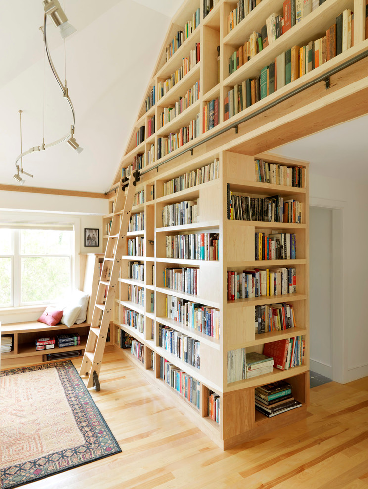 Photo of a country family room in Burlington with a library, white walls and light hardwood floors.