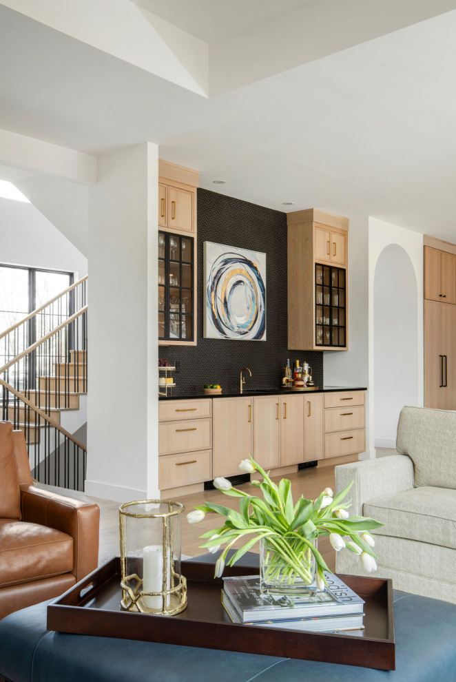 Wet bar - mid-sized transitional single-wall light wood floor and beige floor wet bar idea in St Louis with an undermount sink, shaker cabinets, light wood cabinets, black backsplash, mosaic tile backsplash, black countertops and quartz countertops