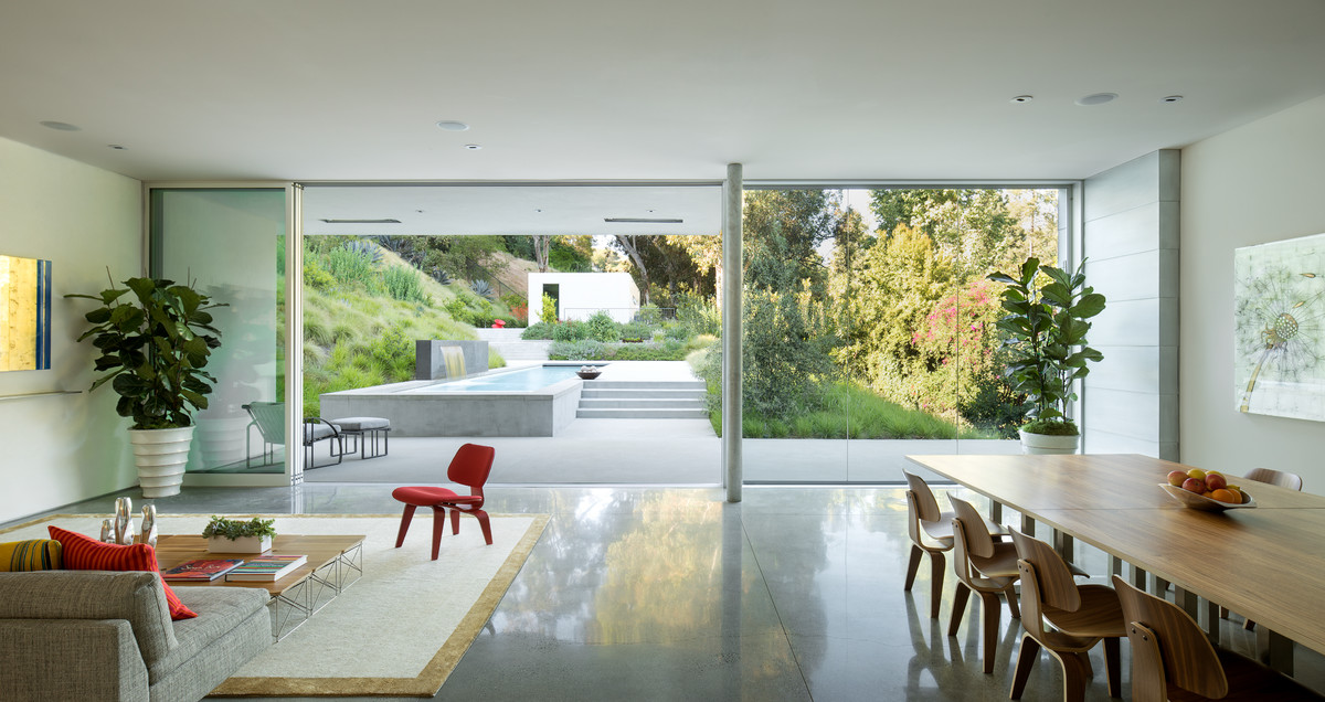 Inspiration for a modern dining room in Los Angeles with white walls, concrete floors and grey floor.