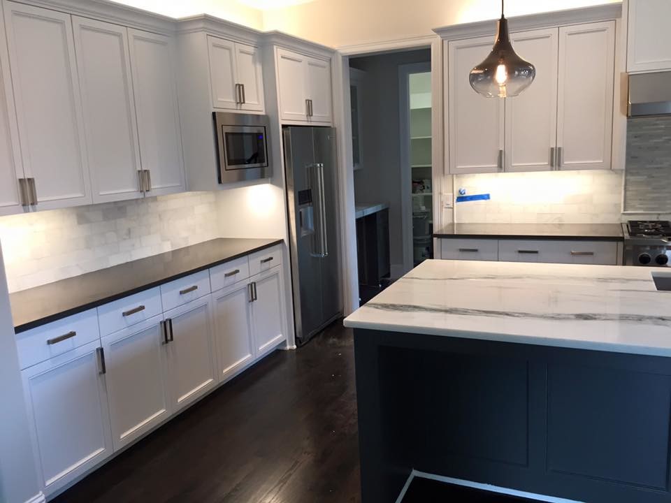 Mid-sized transitional single-wall dark wood floor open concept kitchen photo in Dallas with recessed-panel cabinets, white cabinets, marble countertops, white backsplash, stone tile backsplash, stainless steel appliances and an island