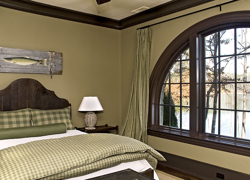 Mid-sized country guest bedroom in Other with beige walls and dark hardwood floors.