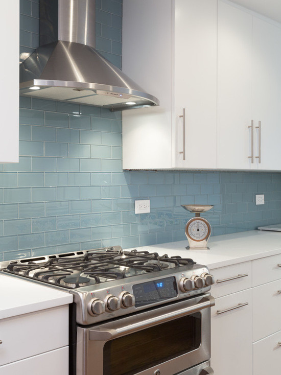 This is an example of a mid-sized modern galley eat-in kitchen in Chicago with an undermount sink, flat-panel cabinets, white cabinets, copper benchtops, blue splashback, subway tile splashback, stainless steel appliances, medium hardwood floors and no island.