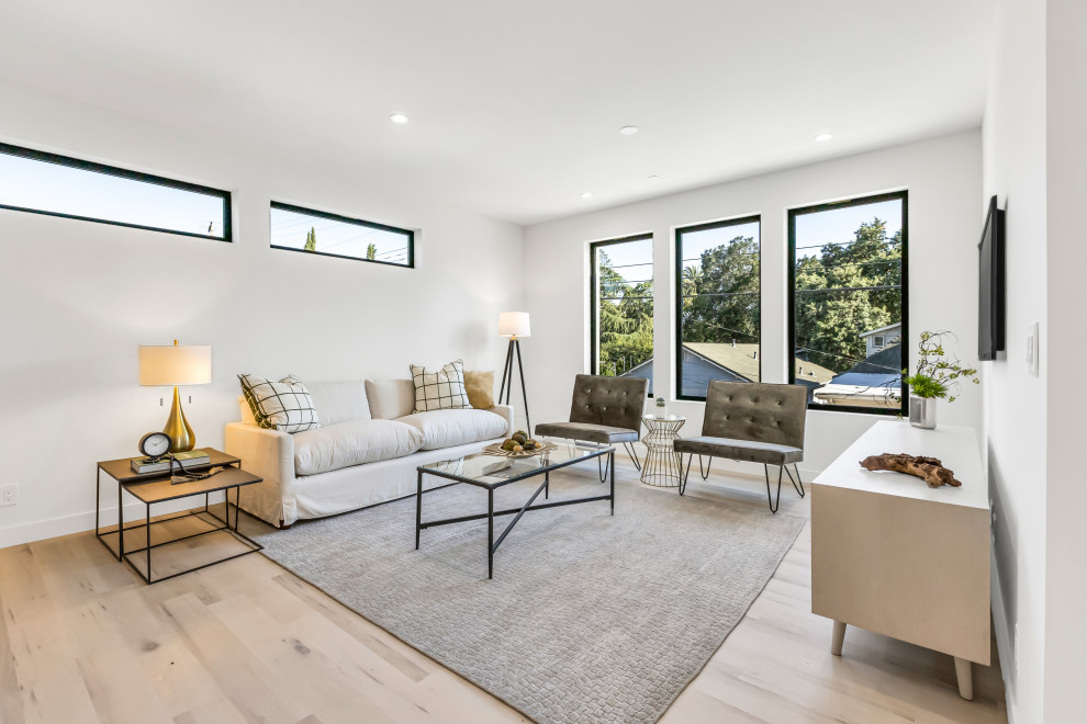 Idee per un grande soggiorno minimalista aperto con sala formale, pareti bianche, pavimento in vinile, TV a parete e pavimento beige