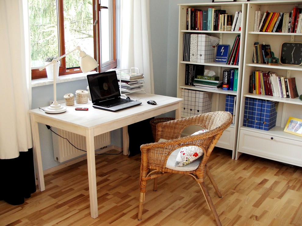 This is an example of an eclectic home office in Other with grey walls, medium hardwood floors and a freestanding desk.