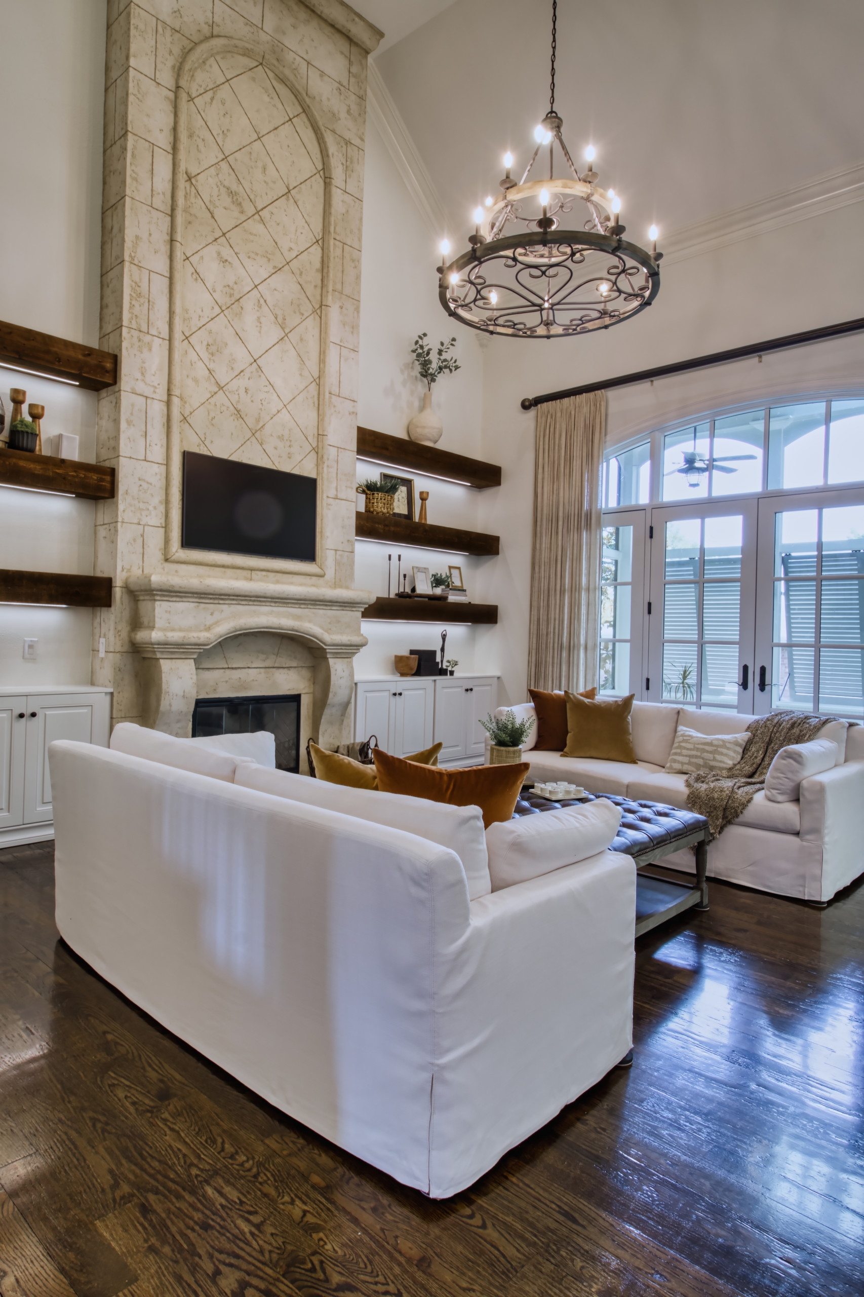 Mid-sized tuscan formal and open concept dark wood floor, brown floor and vaulted ceiling living room photo in Nashville with brown walls, a standard fireplace, a plaster fireplace and a wall-mounted