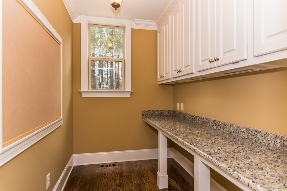 Design ideas for a small modern u-shaped laundry room in Raleigh with recessed-panel cabinets, white cabinets, granite benchtops, medium hardwood floors and brown walls.
