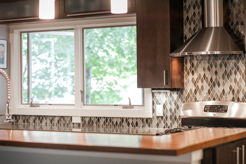 Example of a transitional galley cork floor and gray floor eat-in kitchen design with an undermount sink, flat-panel cabinets, dark wood cabinets, quartz countertops, mosaic tile backsplash, stainless steel appliances and a peninsula
