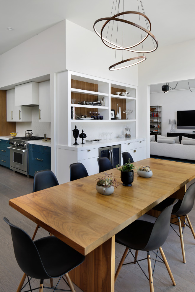 Idee per una grande sala da pranzo aperta verso la cucina minimalista con pareti bianche, pavimento in legno massello medio, pavimento grigio, soffitto a volta e pannellatura