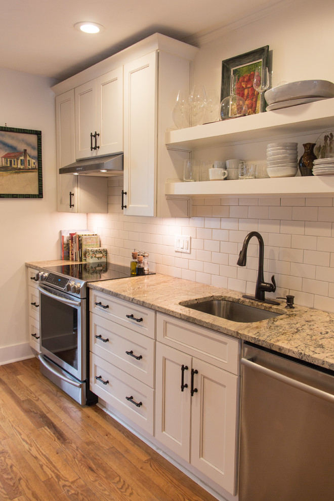 Inspiration for a transitional medium tone wood floor kitchen remodel with granite countertops, subway tile backsplash and stainless steel appliances