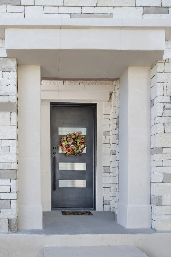 This is an example of a transitional entryway in Austin with a single front door and a gray front door.