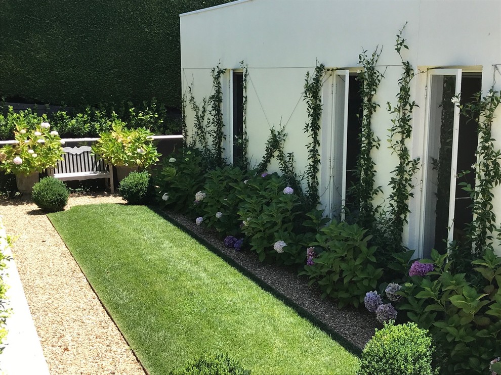 Traditional front yard formal garden in Melbourne with a garden path.