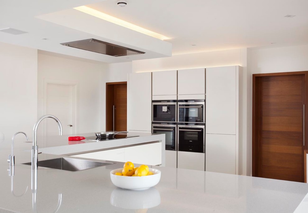 Inspiration for an expansive contemporary l-shaped open plan kitchen in Other with an undermount sink, flat-panel cabinets, white cabinets, quartz benchtops, stainless steel appliances, ceramic floors and with island.