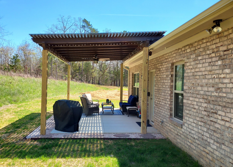 Foto di un piccolo patio o portico design dietro casa con lastre di cemento e una pergola