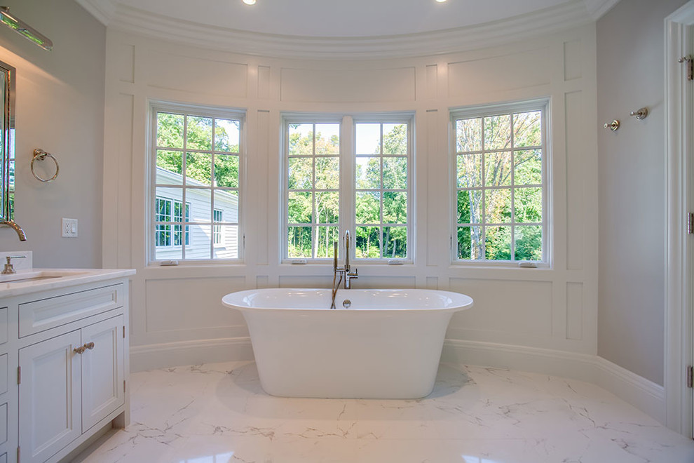 Large transitional master marble floor and white floor freestanding bathtub photo with recessed-panel cabinets, white cabinets, white walls, an undermount sink and a hinged shower door