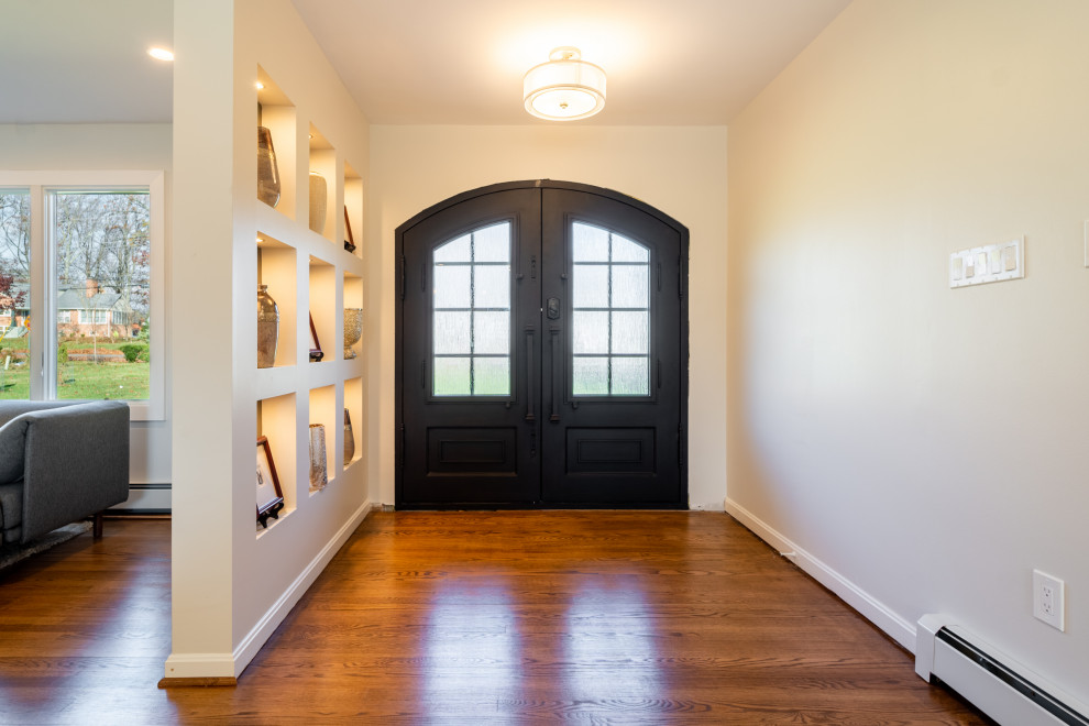 Ispirazione per un ingresso chic con pareti beige, pavimento in legno massello medio, una porta a due ante, una porta in legno scuro e pavimento marrone