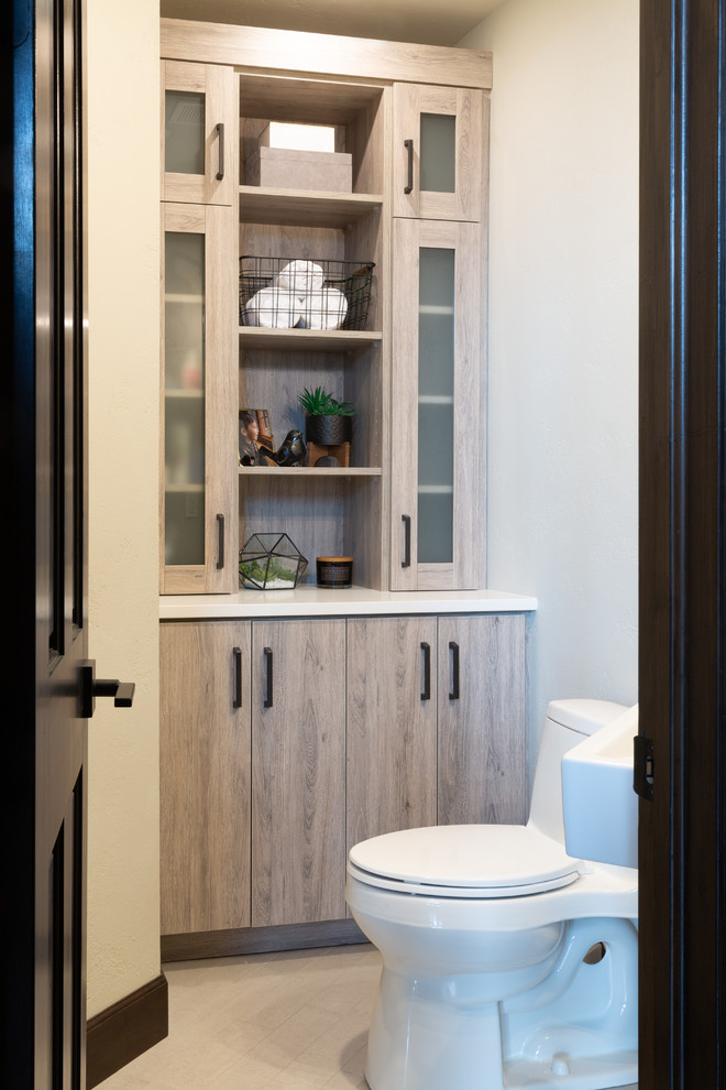 Mid-sized modern powder room in Denver with flat-panel cabinets, grey cabinets, a one-piece toilet, black and white tile, marble, grey walls, ceramic floors, a wall-mount sink, quartzite benchtops, black floor and white benchtops.