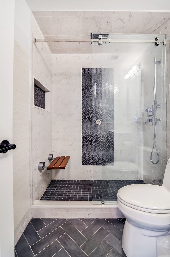 Example of a mid-sized transitional master gray tile, ceramic tile and white tile ceramic tile alcove shower design in New York with a one-piece toilet, flat-panel cabinets, white cabinets, white walls, solid surface countertops and a niche