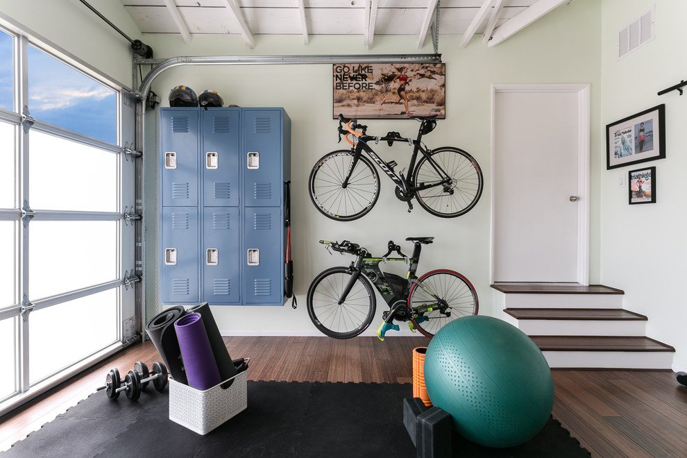 Mid-sized contemporary home yoga studio in Los Angeles with green walls, medium hardwood floors and brown floor.