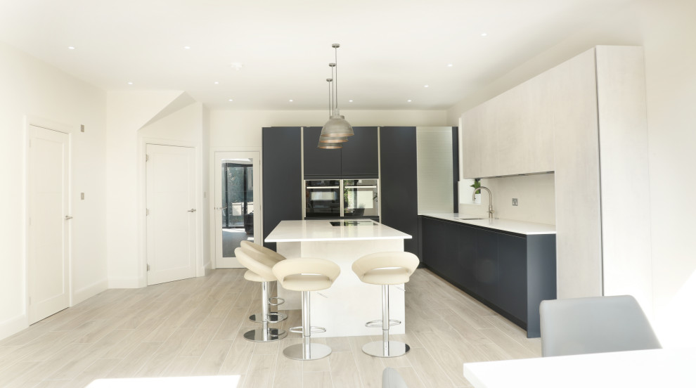 Foto di una grande cucina minimal con ante lisce, ante blu, top in quarzite, paraspruzzi bianco, paraspruzzi in lastra di pietra, pavimento in laminato, pavimento grigio e top bianco